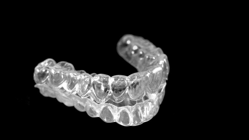 Plastic braces to straighten teeth in a black background